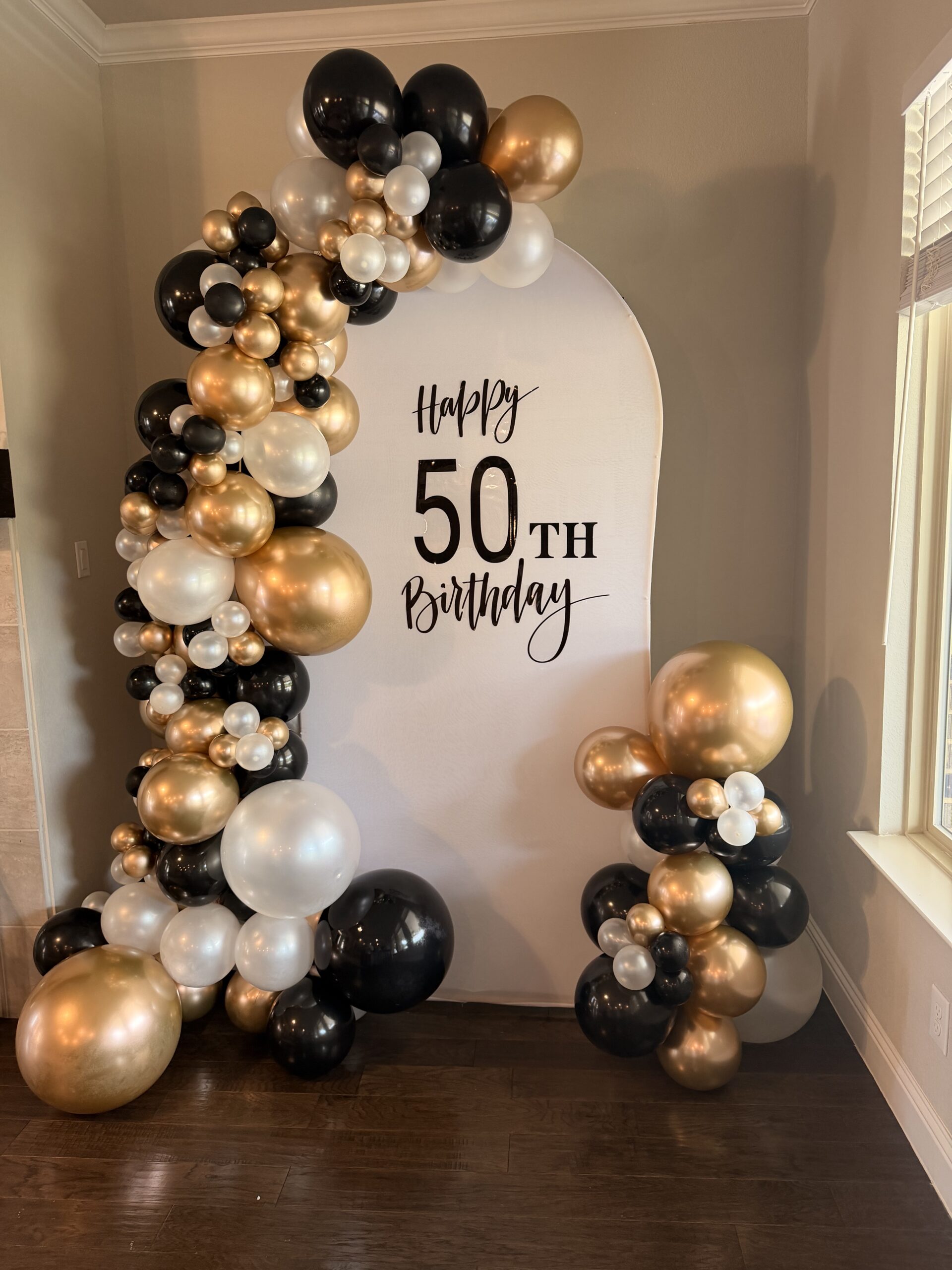 Black and gold balloon arch
